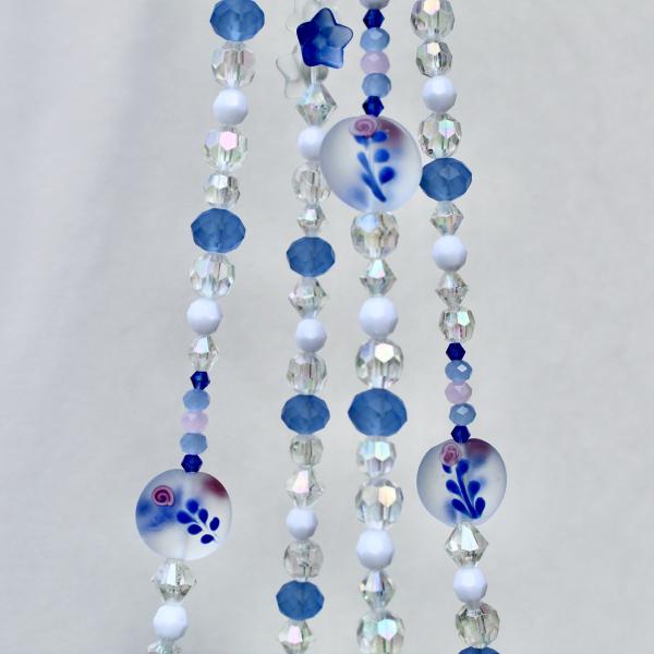 The full Blue Delft Bloom beaded plant hanger, showcasing its classic blue and white coastal charm.